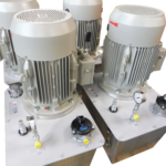 Nahaufnahme zweier Elektromotoren IE2 eines RRG Hydraulikaggregats Standard mit Anschlüssen, Manometer und Ventilen auf dem Tankdeckel